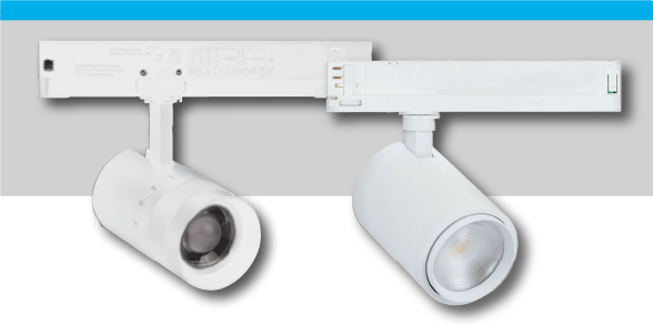Zwei wei&szlig;e LED-Strahler sind an einer Schiene befestigt, die an der Decke montiert ist. Einer der Strahler hat eine klare Linse, der andere eine matte Abdeckung. Kontext: grauer Hintergrund.