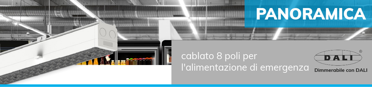 Illuminazione industriale in un supermercato o magazzino, primo piano di una barra luminosa bianca con scritta cablato 8 poli per l'alimentazione di emergenza e logo DALI con Dimmerabile con DALI.